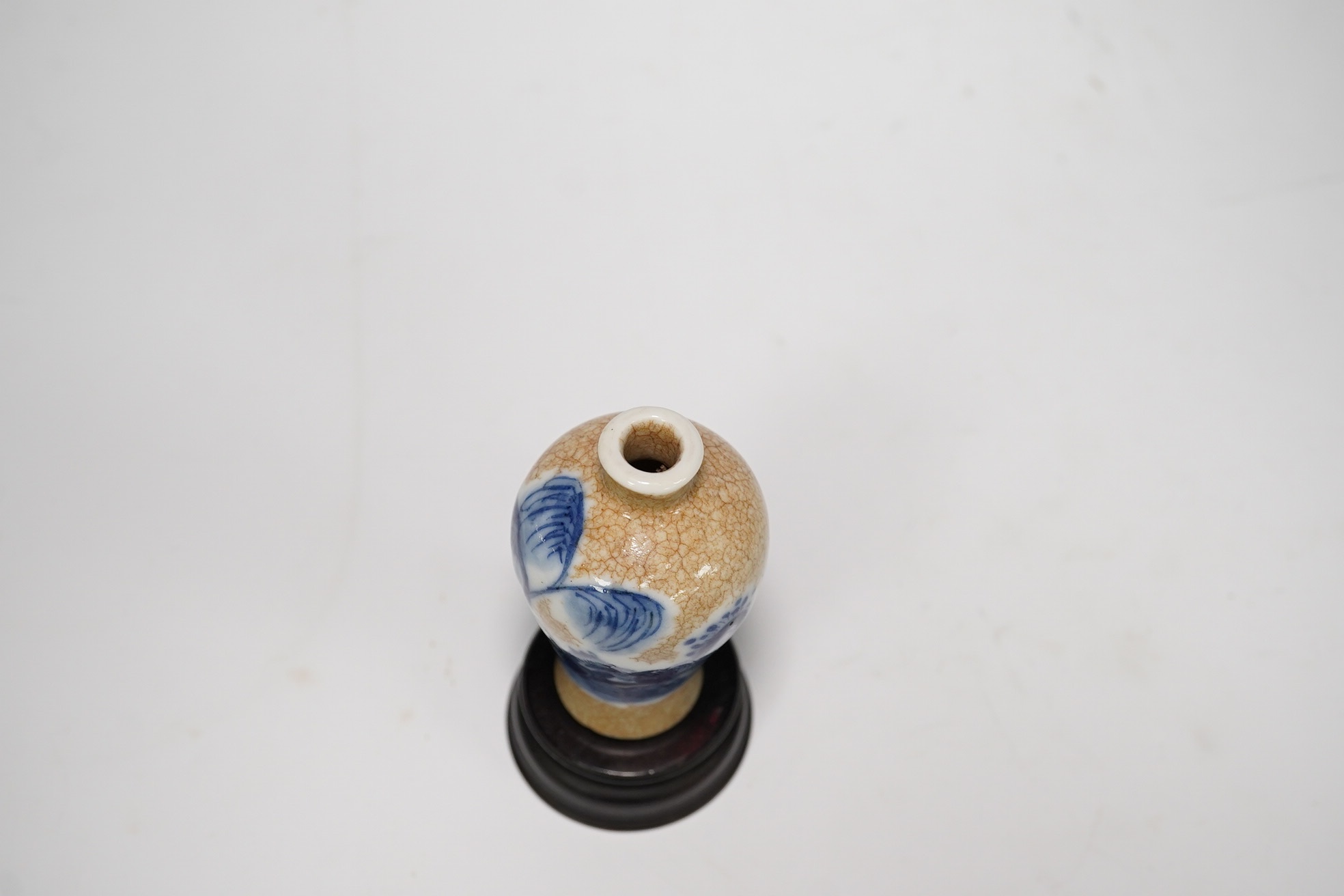 A Chinese blue and white crackle glaze snuff bottle, late 19th century and stand, 8cm high. Condition - good